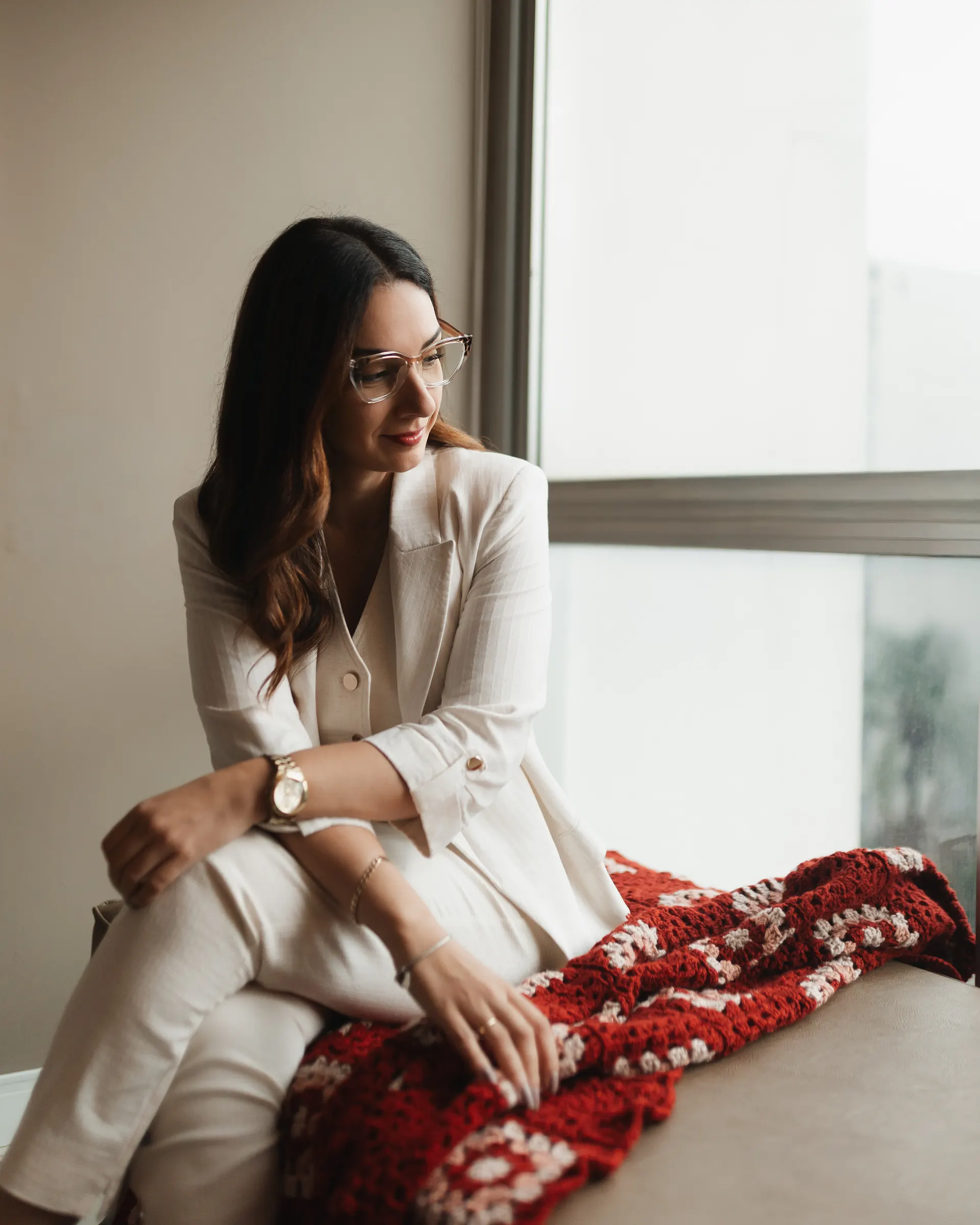 Gabriela Vargas de óculos, sentada junto à janela