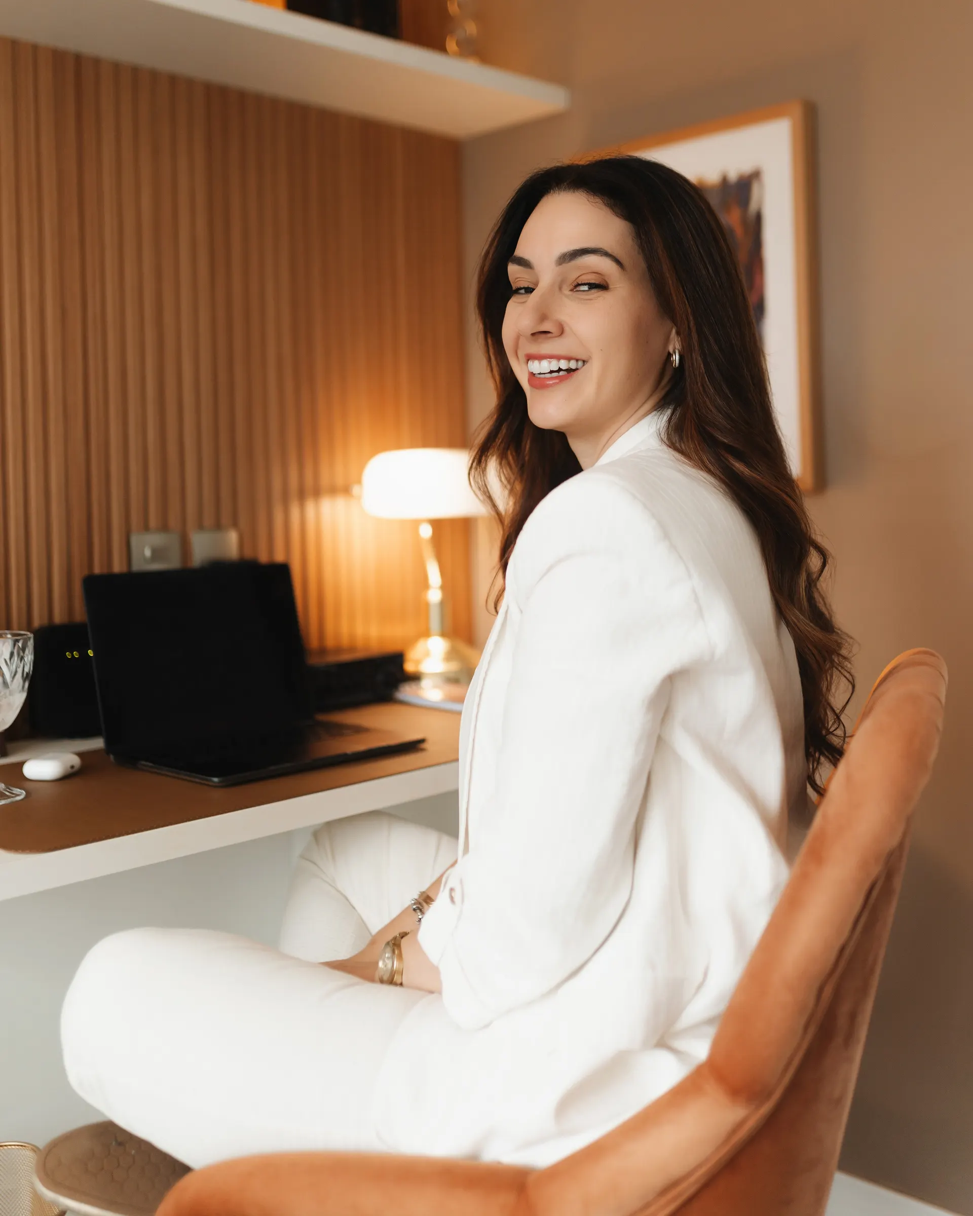 Gabriela Vargas sentada à mesa do consultório, virada para a câmera