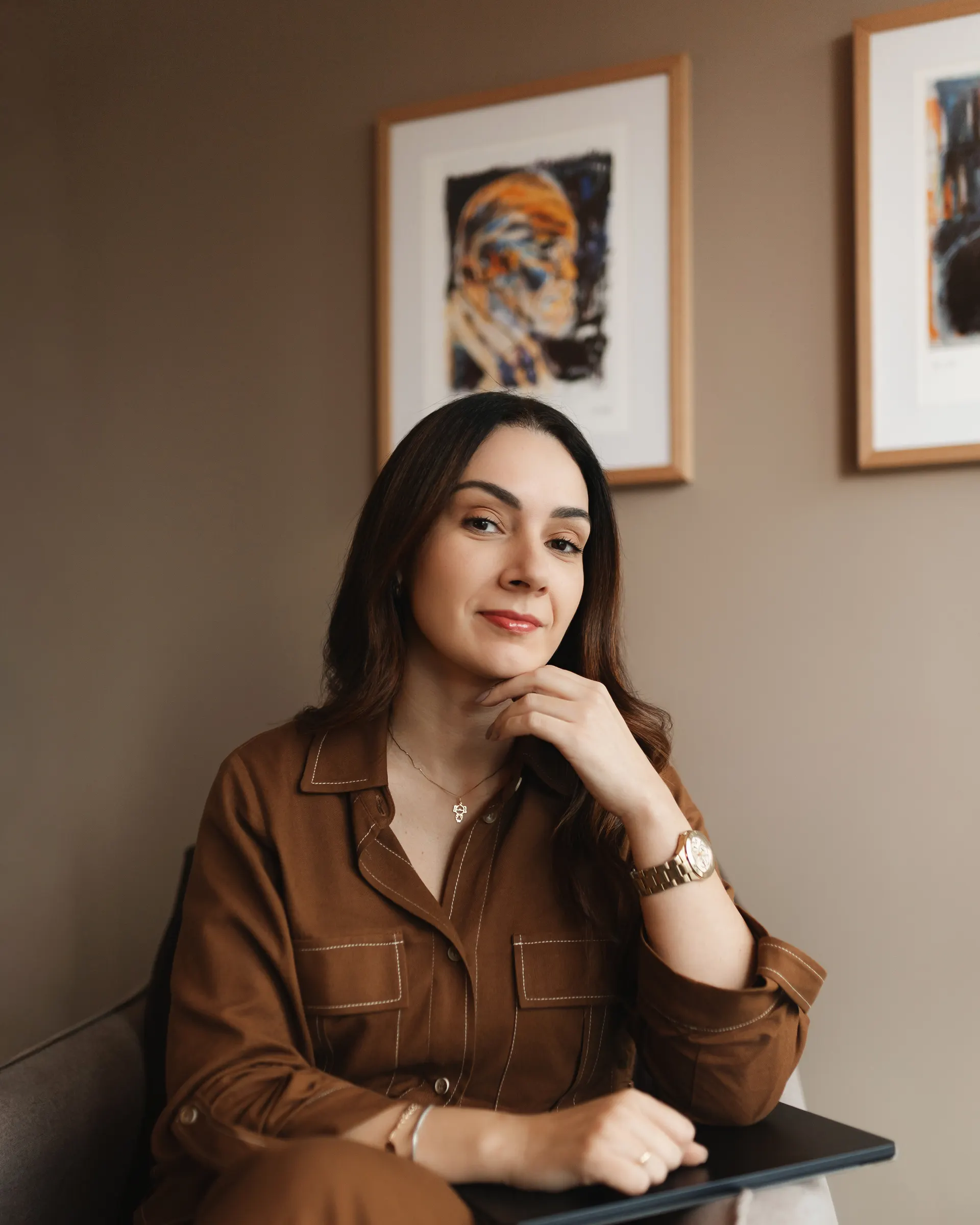 Gabriela Vargas, psicóloga e psicanalista, sentada de frente para a câmera com a mão apoiada no queixo